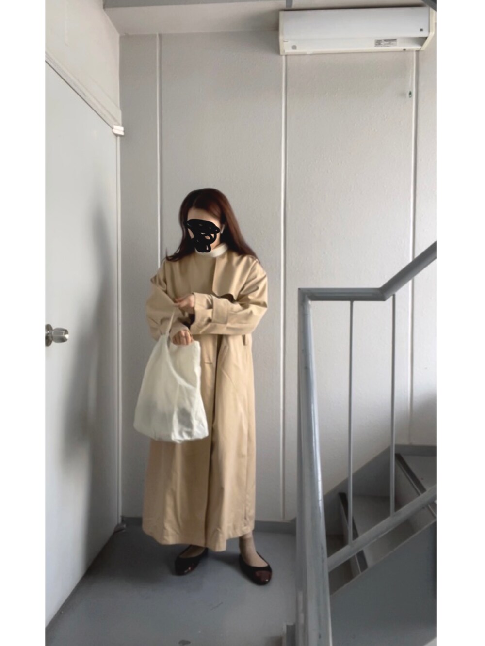 ホワイト系のトートバッグ、ホワイト系のニット/セーター、ベージュ系のトレンチコートを着用したレディースの冬コーディネートの4枚目の写真