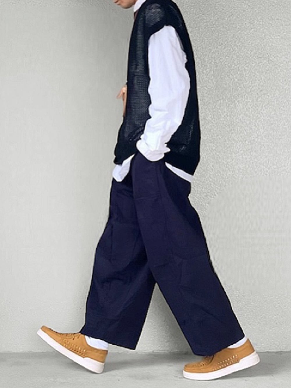 ブラウン系のモカシン/デッキシューズ、ブラック系のニット/セーター、ホワイト系のシャツ/ブラウスを着用したメンズの春コーディネートの2枚目の写真