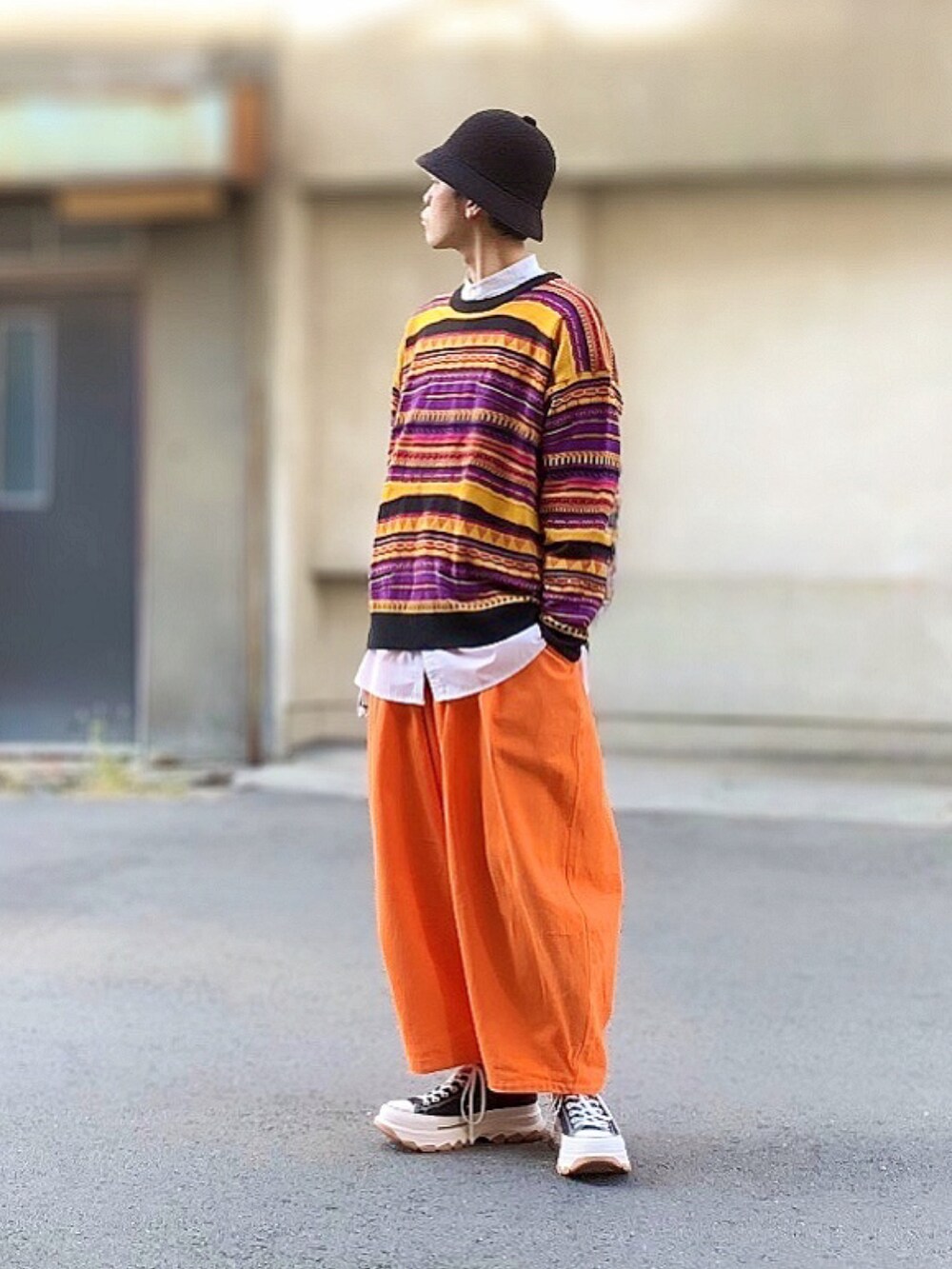 グリーン系のモッズコート、その他のニット/セーター、オレンジ系のカーゴパンツを着用したメンズの秋コーディネートの2枚目の写真