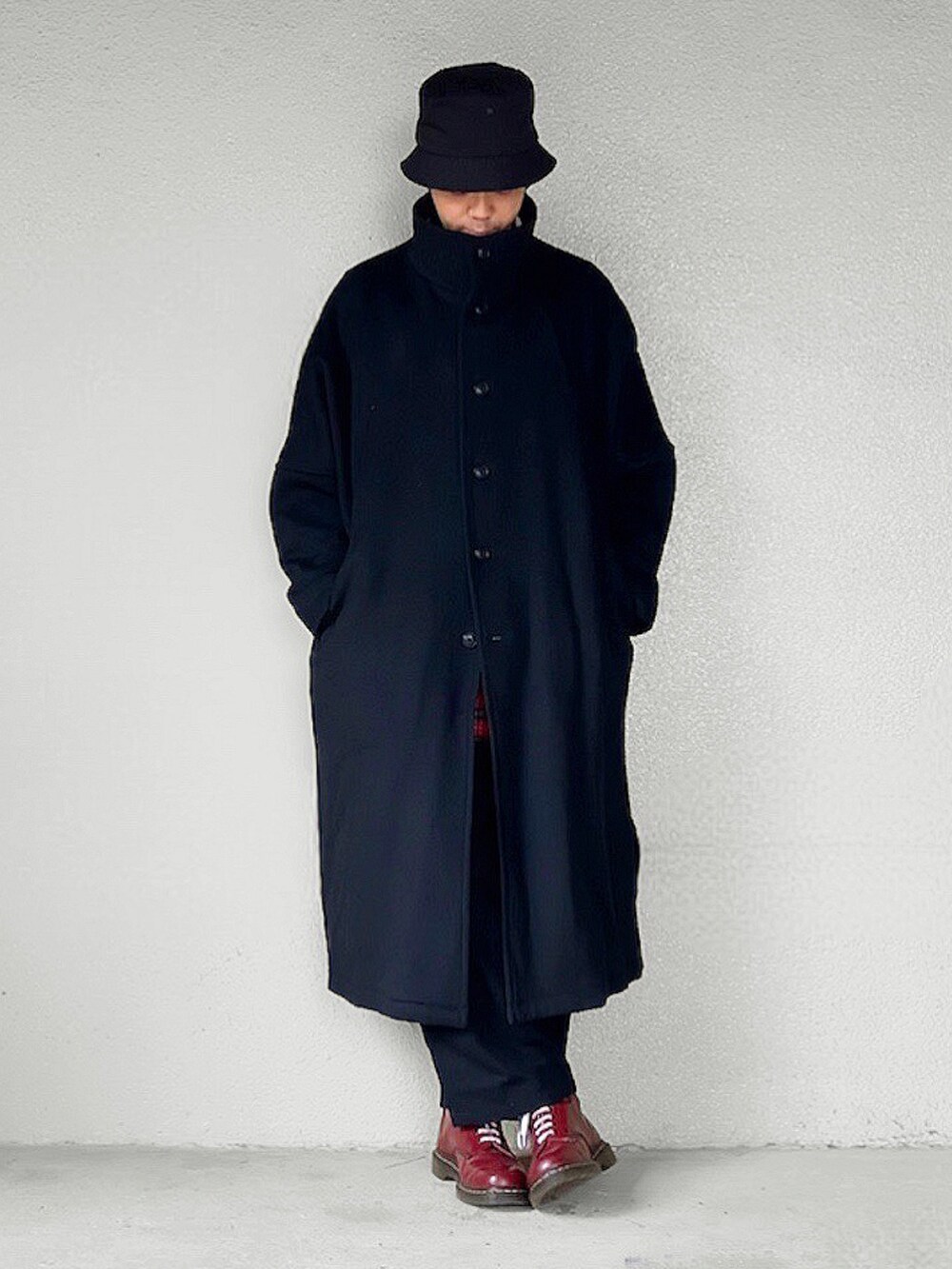 ホワイト系のニット/セーター、レッド系のシャツ/ブラウス、レッド系のブーツを着用したメンズの冬コーディネートの2枚目の写真