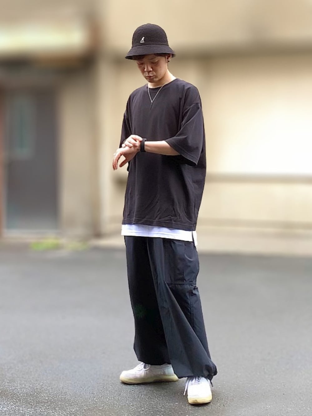 ブラック系のTシャツ/カットソー、ブラック系のカーゴパンツ、ホワイト系のスニーカーを着用したメンズの夏コーディネートの2枚目の写真