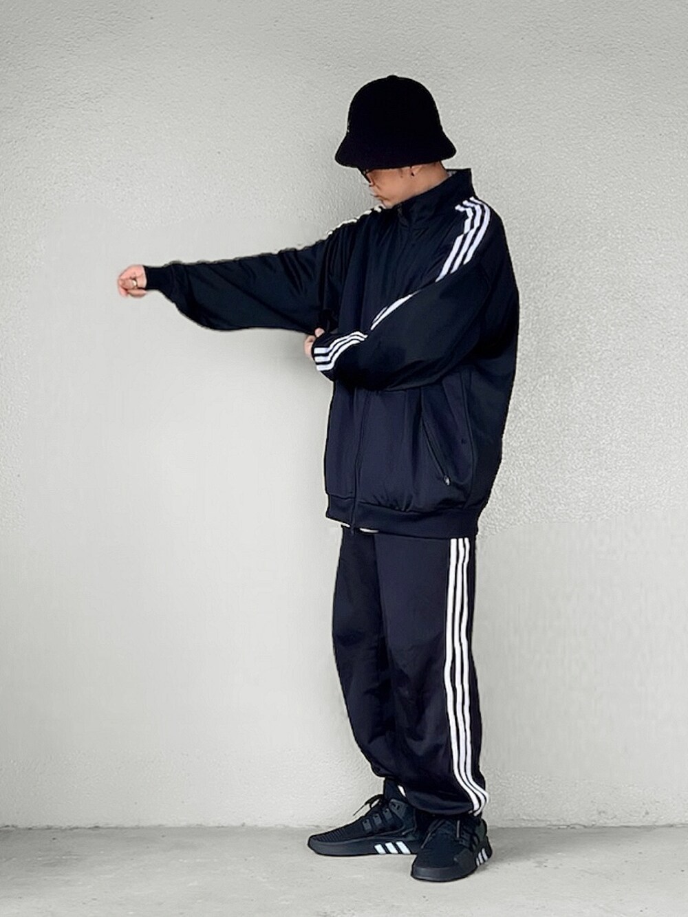 ブラック系のスニーカー、ブラック系のハットを着用したメンズの秋コーディネートの2枚目の写真