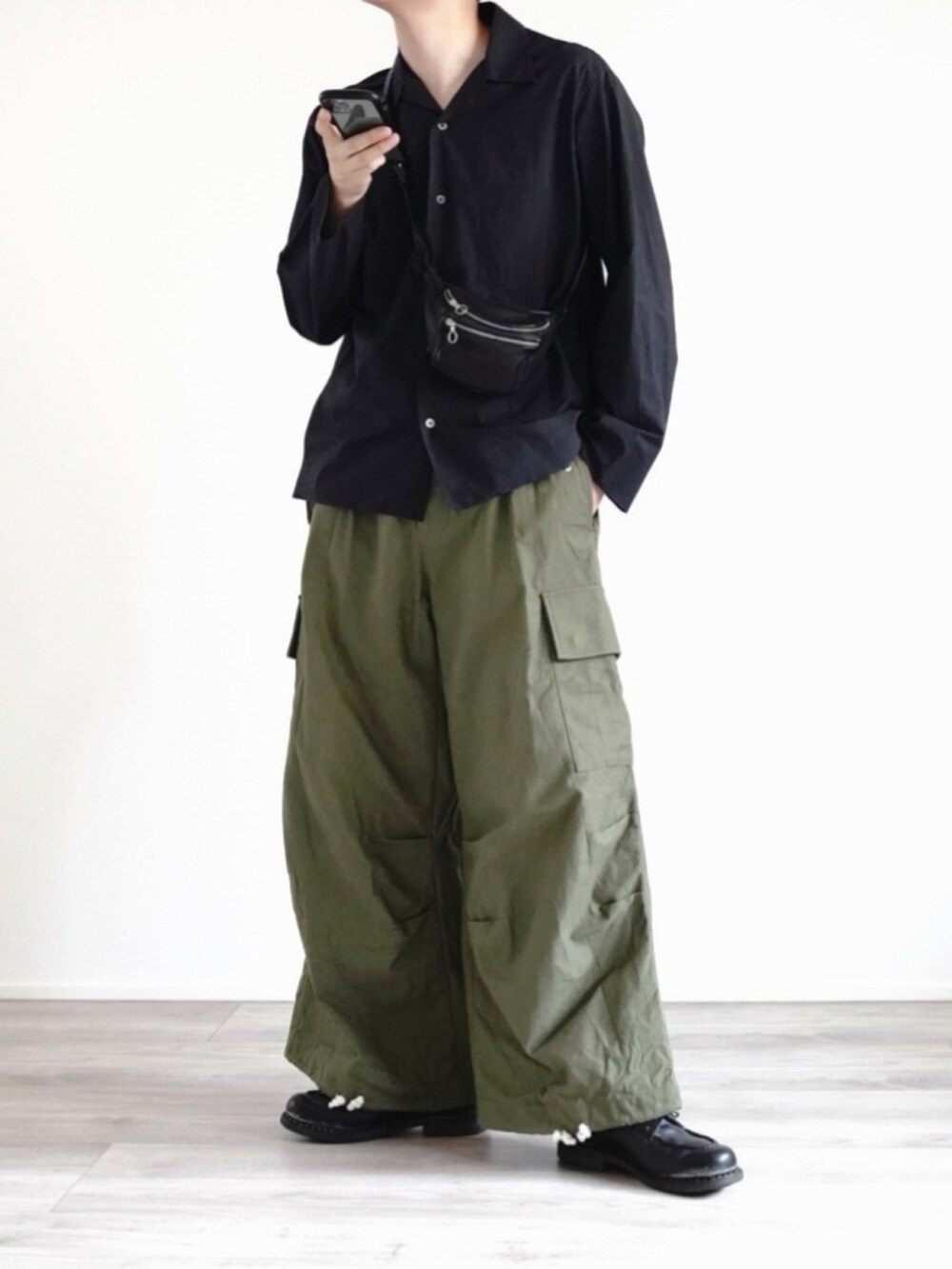 ブラック系のシャツ/ブラウス、ブラック系のボディバッグ/ウエストポーチ、グリーン系のカーゴパンツを着用したメンズの夏コーディネートの2枚目の写真