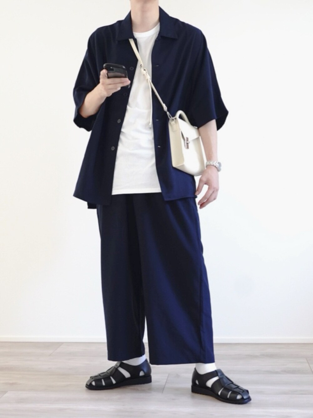 ブルー系のセットアップ、ホワイト系のショルダーバッグ、ブラック系のサンダルを着用したメンズの夏コーディネートの2枚目の写真
