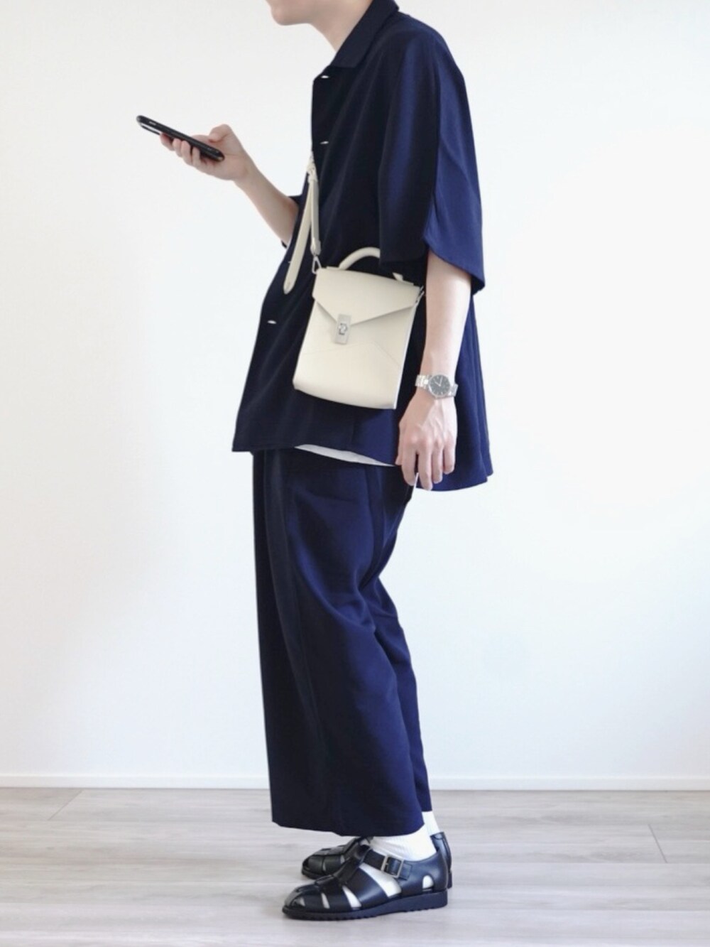 ブルー系のセットアップ、ホワイト系のショルダーバッグ、ブラック系のサンダルを着用したメンズの夏コーディネートの4枚目の写真