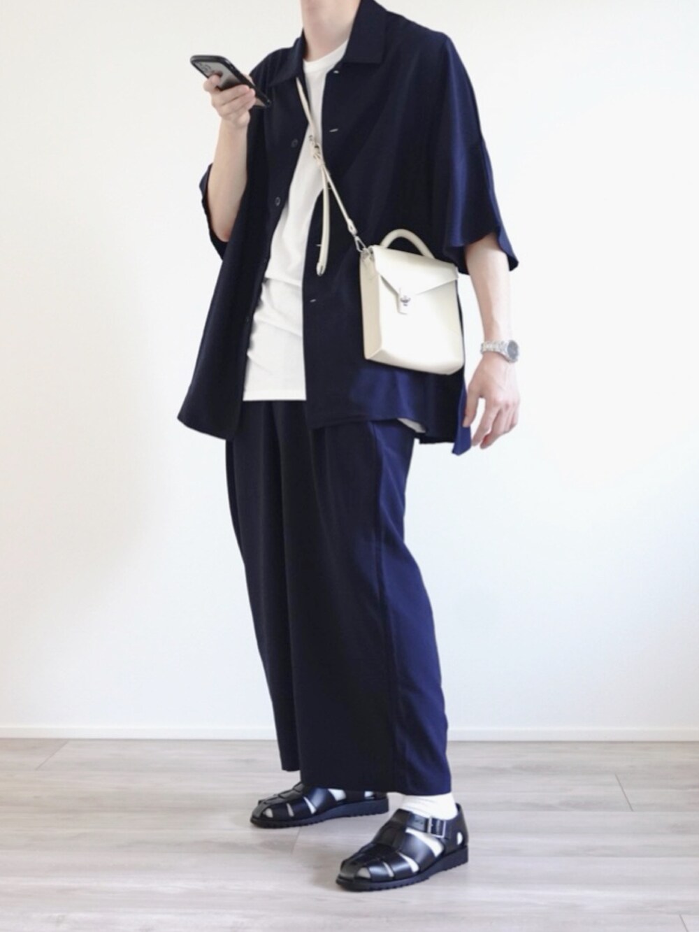 ブルー系のセットアップ、ホワイト系のショルダーバッグ、ブラック系のサンダルを着用したメンズの夏コーディネートの3枚目の写真