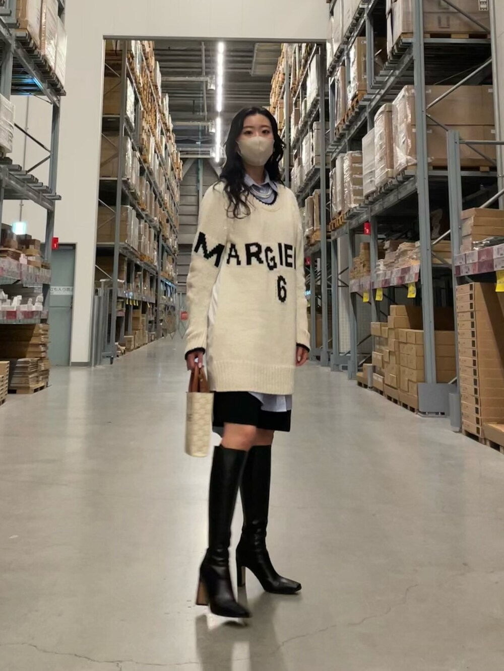 ホワイト系のニット/セーター、ブラック系のパンツ、ブルー系のシャツ/ブラウスを着用したレディースの春コーディネートの2枚目の写真