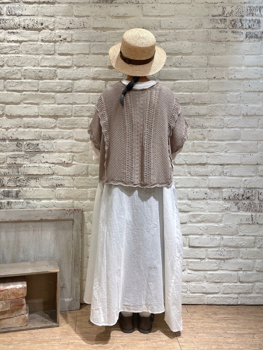 ブラック系のベスト、ホワイト系のワンピース、ベージュ系のハンドバッグを着用したレディースの春コーディネートの3枚目の写真