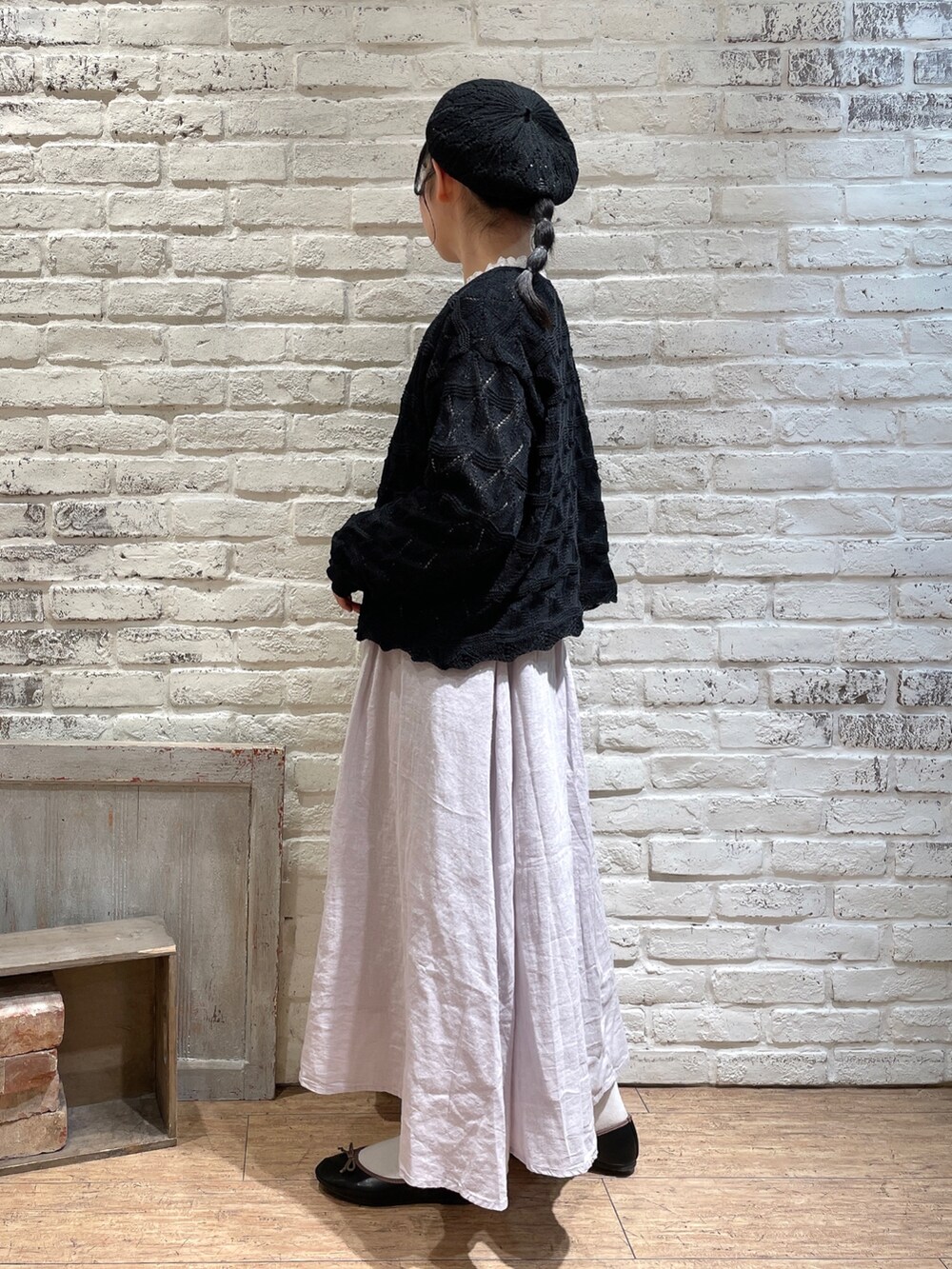 ホワイト系のシャツ/ブラウス、ブラック系のカーディガン/ボレロ、ピンク系のスカートを着用したレディースの春コーディネートの2枚目の写真