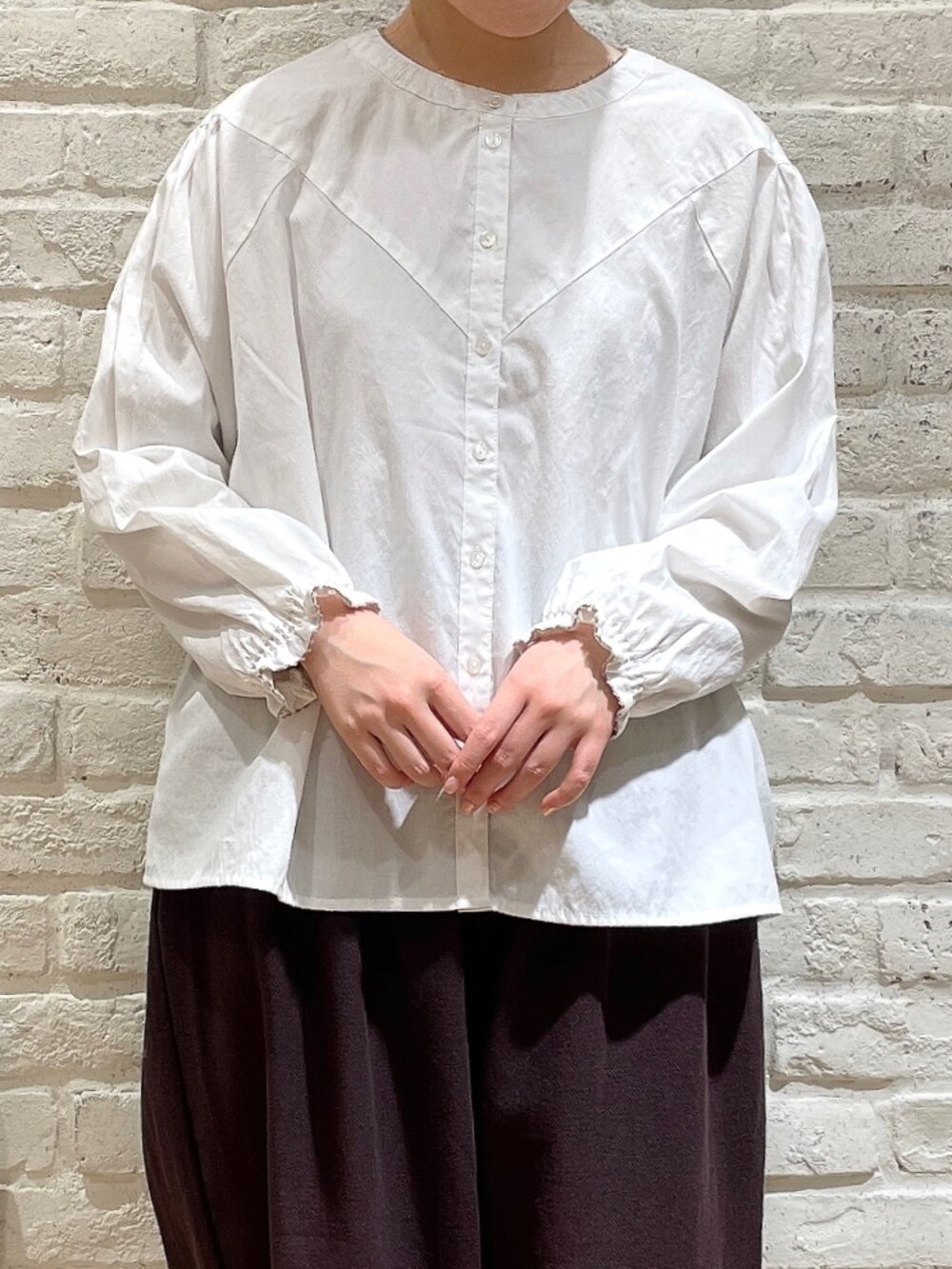 ホワイト系のカーディガン/ボレロ、ホワイト系のシャツ/ブラウス、ホワイト系のハンドバッグを着用したレディースの春コーディネートの2枚目の写真