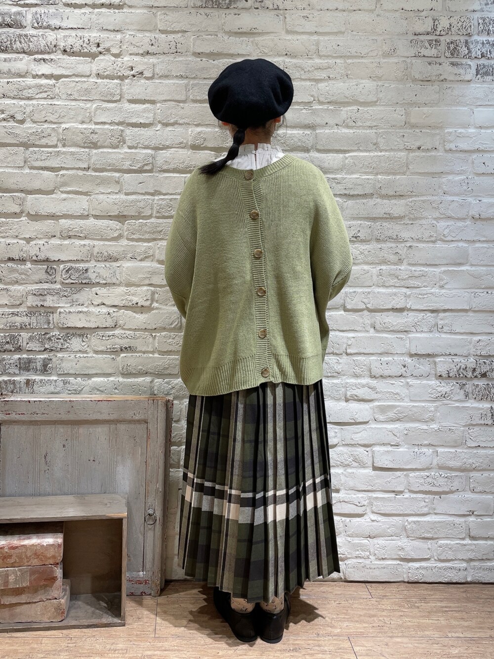 ホワイト系のシャツ/ブラウス、グリーン系のニット/セーター、ブルー系のスカートを着用したレディースの冬コーディネートの3枚目の写真