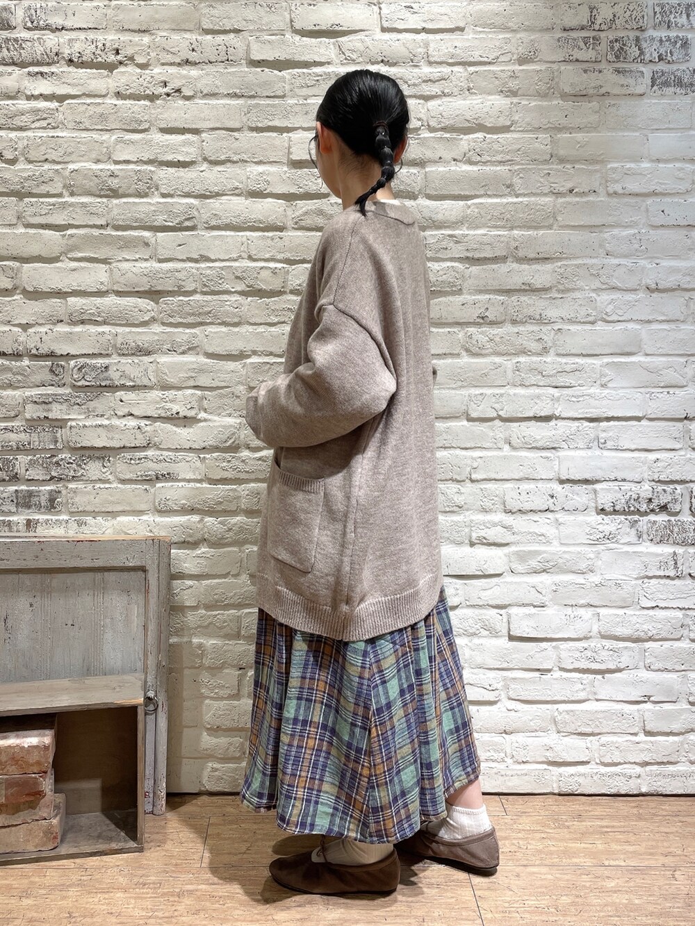 ホワイト系のTシャツ/カットソー、ベージュ系のカーディガン/ボレロ、グリーン系のスカートを着用したレディースの秋コーディネートの2枚目の写真