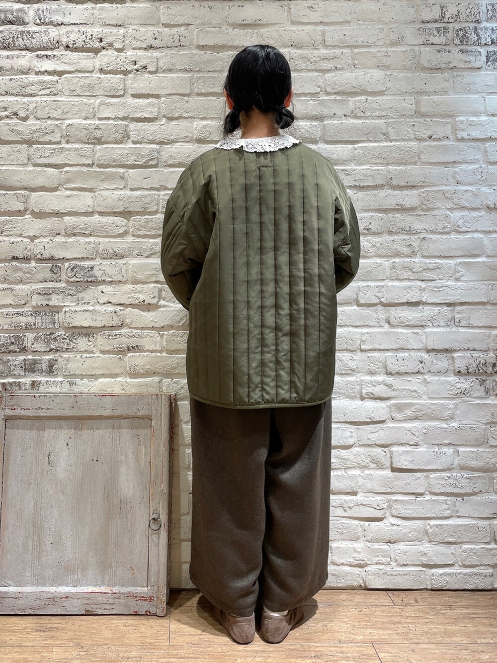 ホワイト系のシャツ/ブラウス、グリーン系のノーカラージャケット、ブラック系のパンツを着用したレディースの冬コーディネートの3枚目の写真