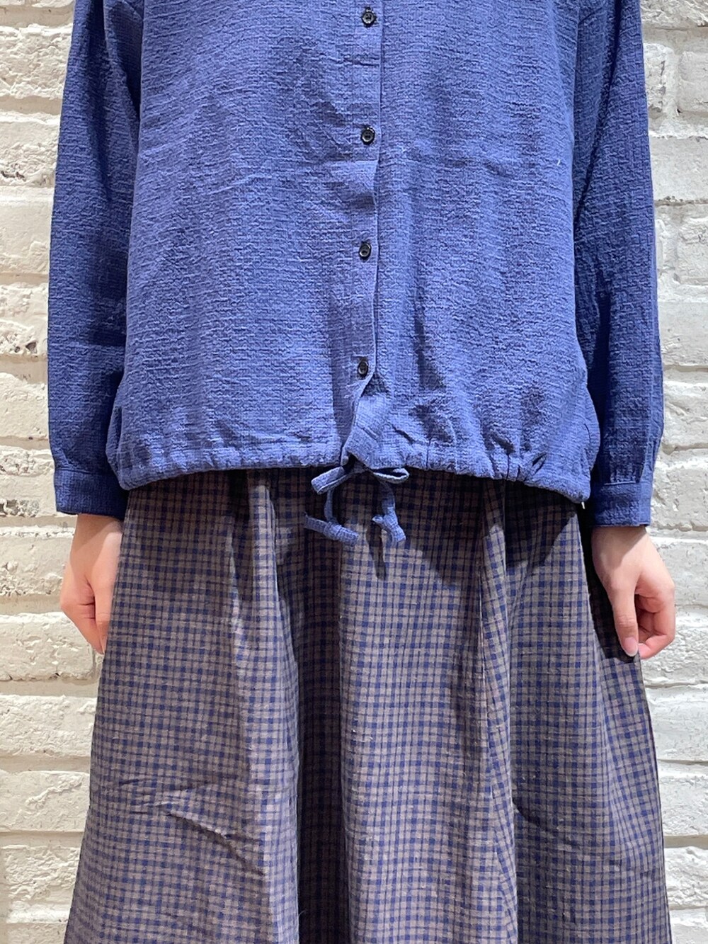 ブルー系のシャツ/ブラウス、ブラック系のハンドバッグ、ブルー系のスカートを着用したレディースの秋コーディネートの2枚目の写真