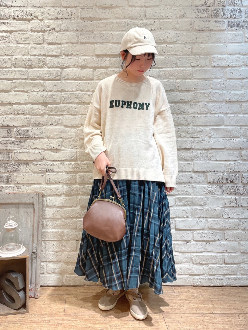 ブルー系のノーカラージャケット、ホワイト系のニット/セーター、グリーン系のスカートを着用したレディースの秋コーディネートの4枚目の写真