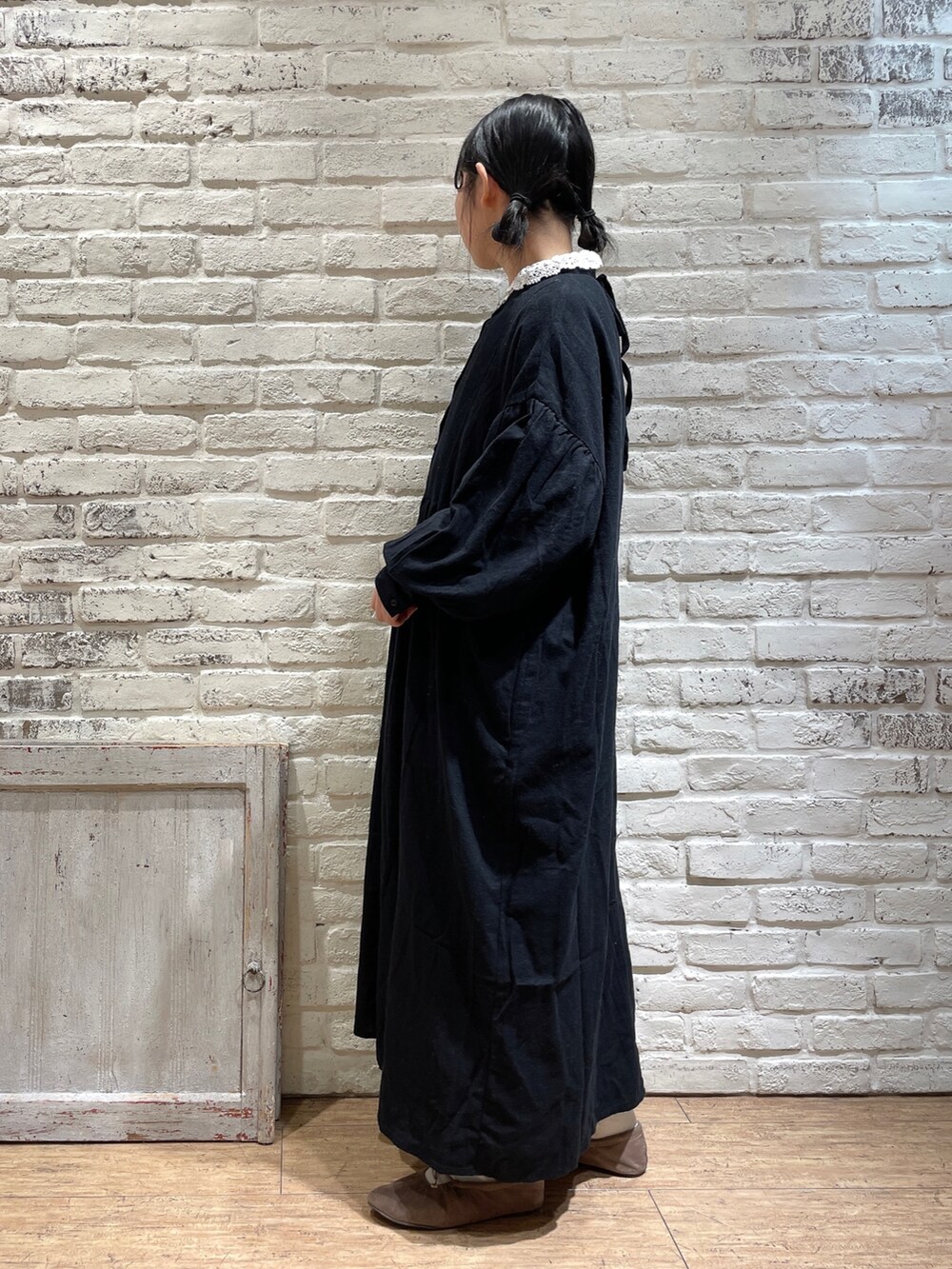 ブラック系のワンピース、ブラウン系のバレエシューズ、ホワイト系のシャツ/ブラウスを着用したレディースの冬コーディネートの2枚目の写真