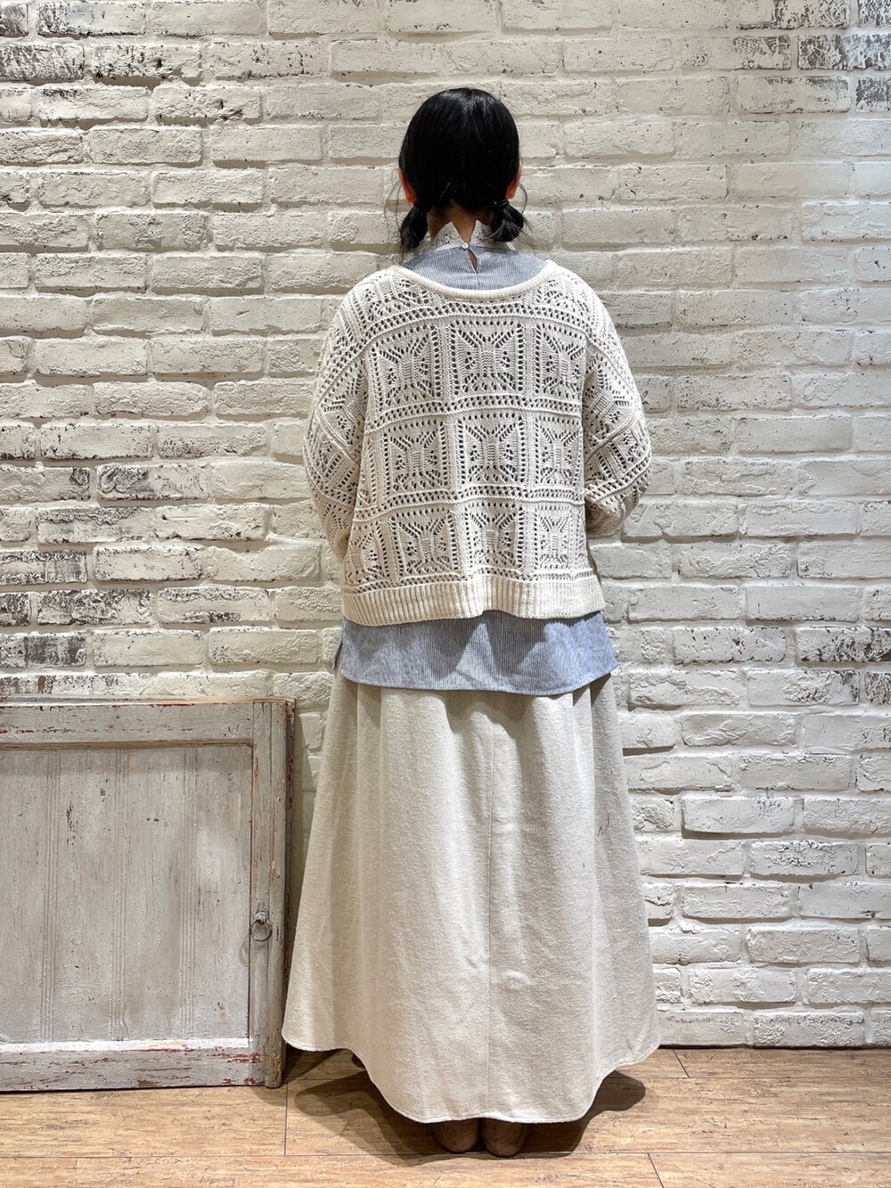 ブルー系のシャツ/ブラウス、ホワイト系のニット/セーター、ベージュ系のスカートを着用したレディースの冬コーディネートの4枚目の写真