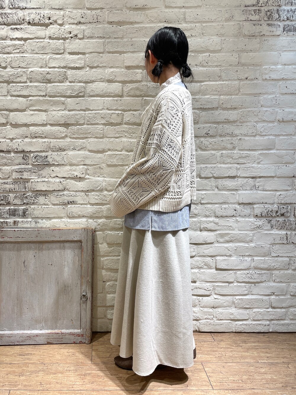 ブルー系のシャツ/ブラウス、ホワイト系のニット/セーター、ベージュ系のスカートを着用したレディースの冬コーディネートの3枚目の写真