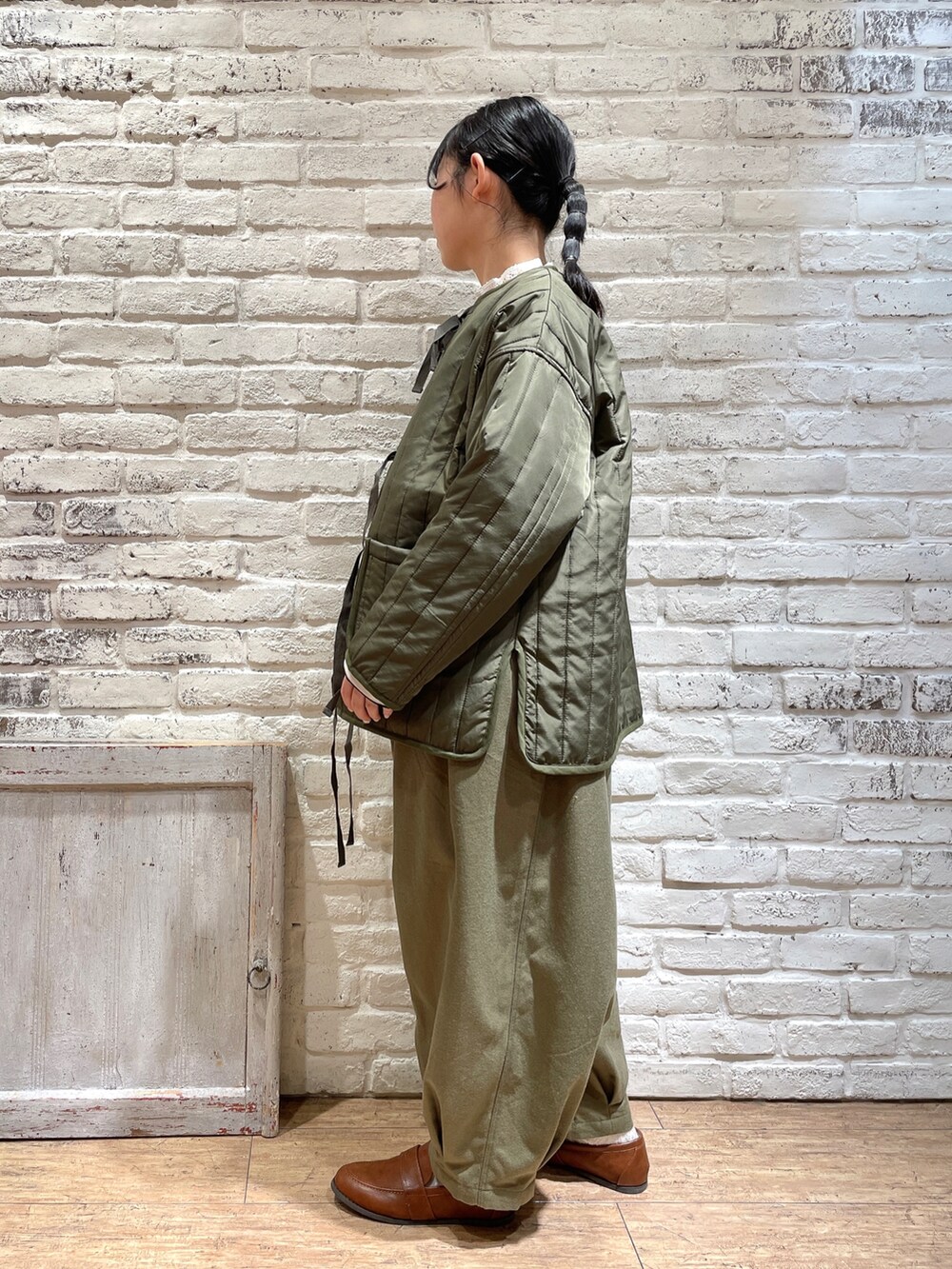 ブルー系のシャツ/ブラウス、ホワイト系のTシャツ/カットソー、グリーン系のノーカラージャケットを着用したレディースの冬コーディネートの2枚目の写真