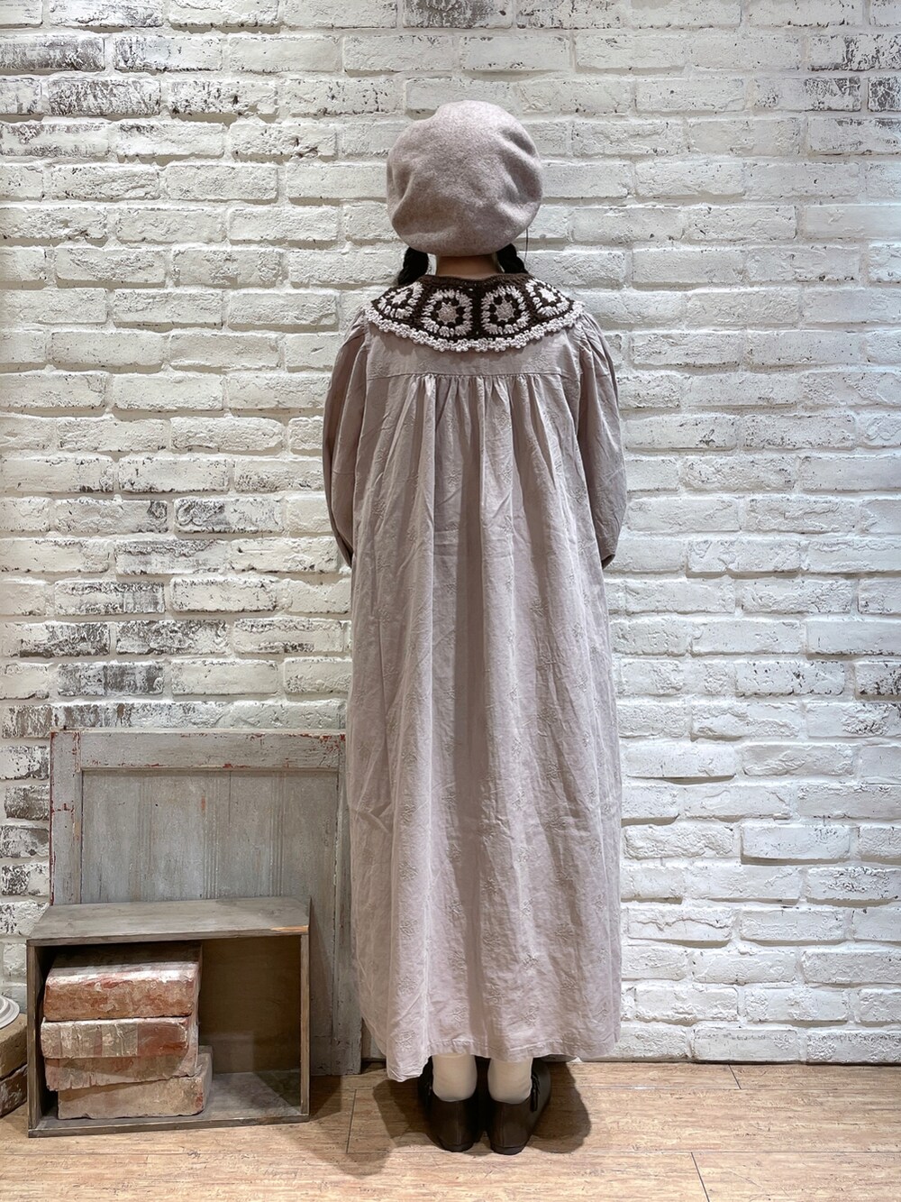 ブラウン系のハンドバッグ、ベージュ系のワンピース、ブラウン系のパンプスを着用したレディースの秋コーディネートの3枚目の写真