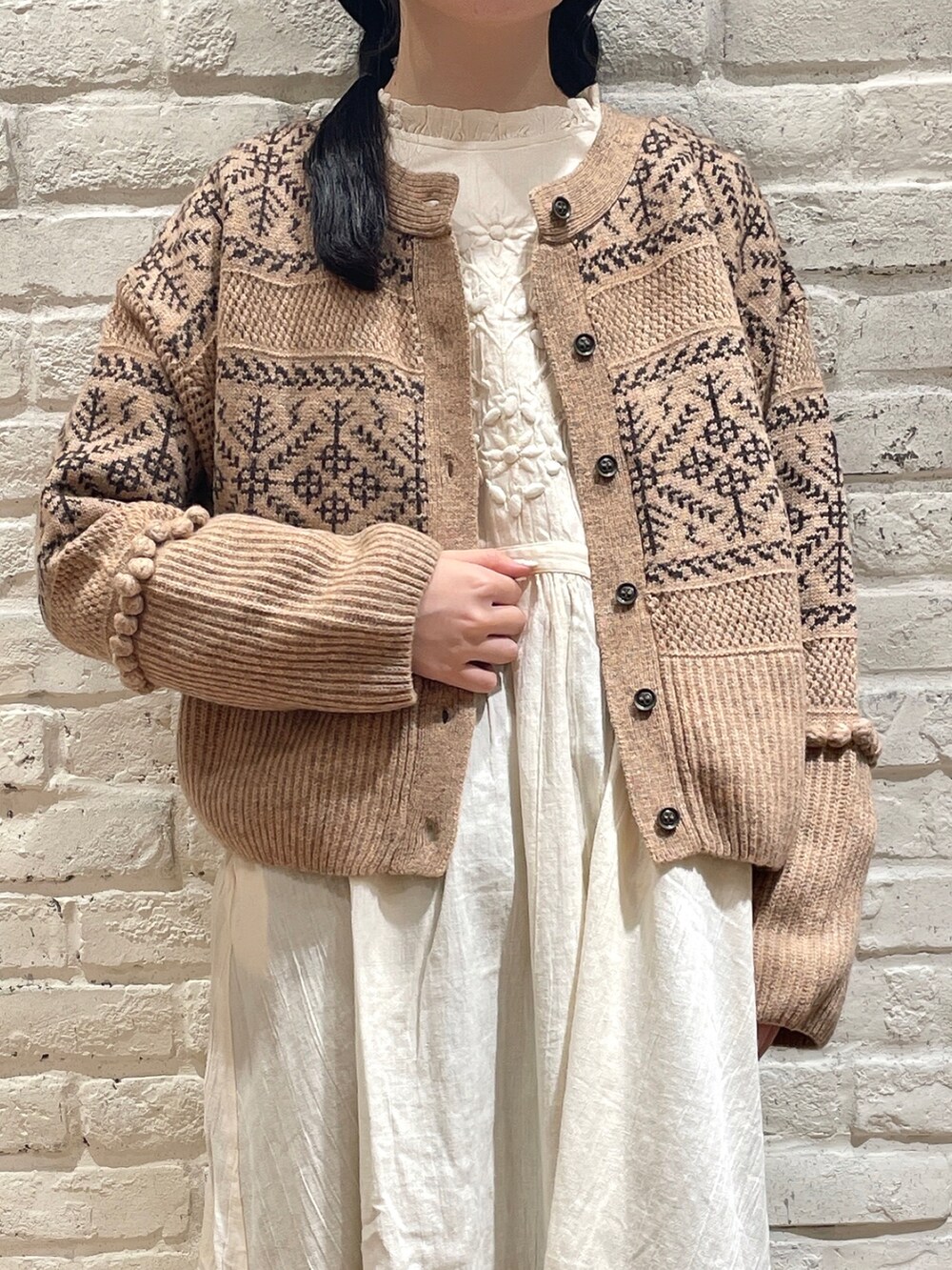 ホワイト系のワンピース、オレンジ系のカーディガン/ボレロ、ブラック系のサンダルを着用したレディースの秋コーディネートの2枚目の写真