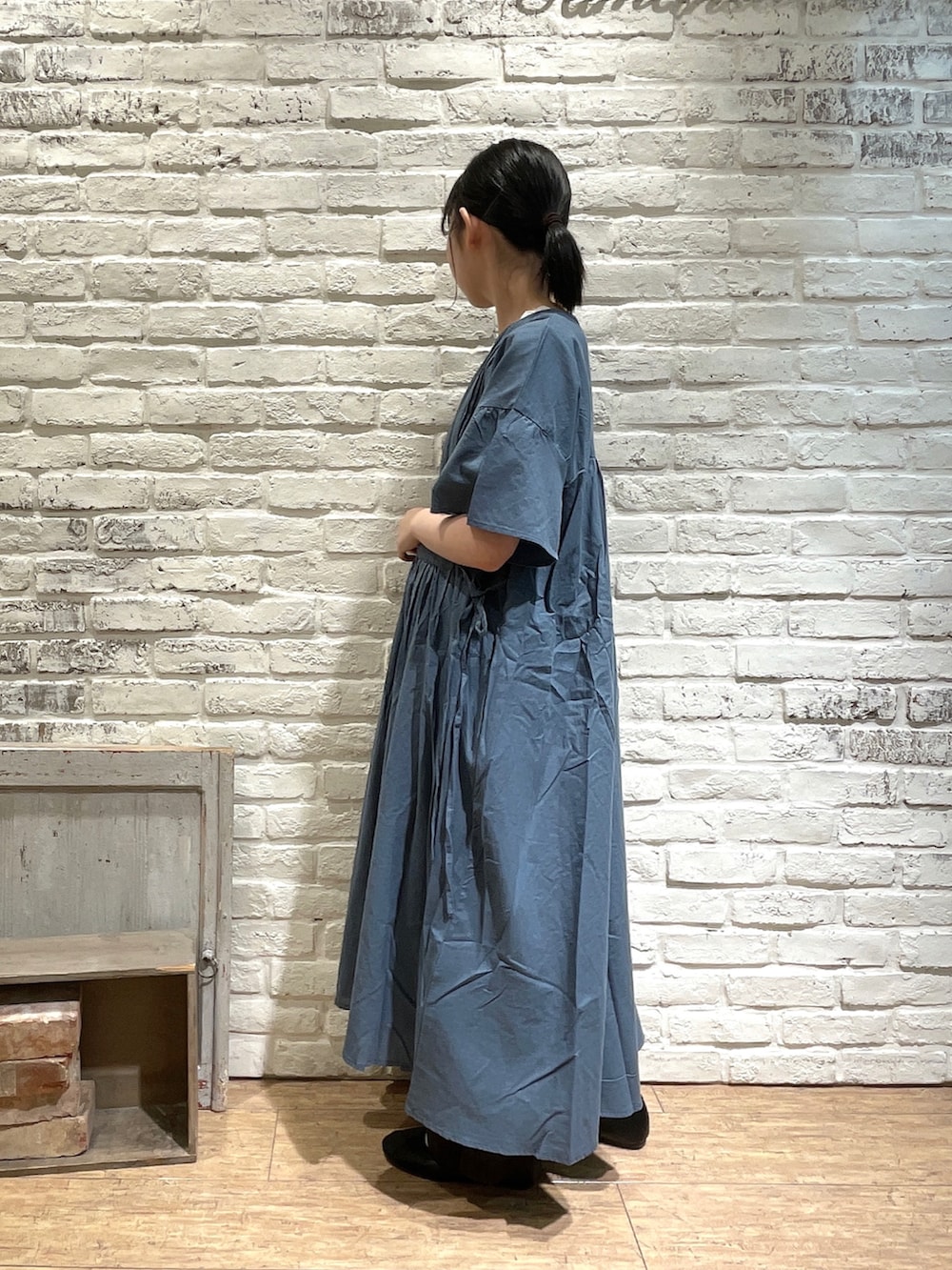 ベージュ系のトートバッグ、グリーン系のワンピース、ホワイト系のTシャツ/カットソーを着用したレディースの夏コーディネートの3枚目の写真