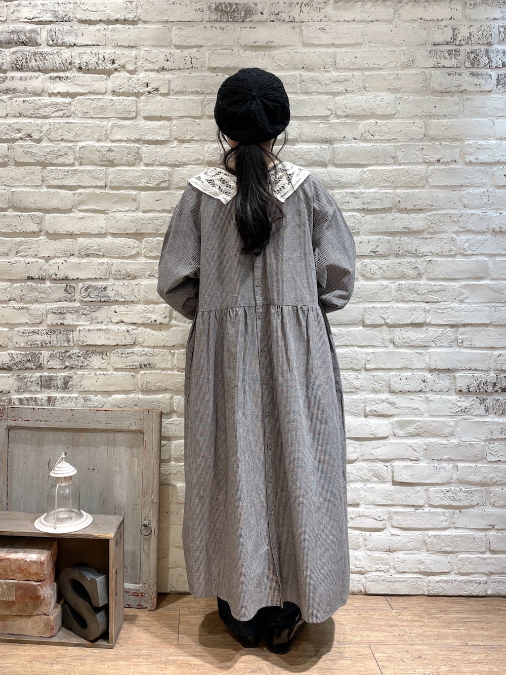 ブラック系のハンドバッグ、ブルー系のデニムパンツ、ブラック系のパンプスを着用したレディースの冬コーディネートの3枚目の写真