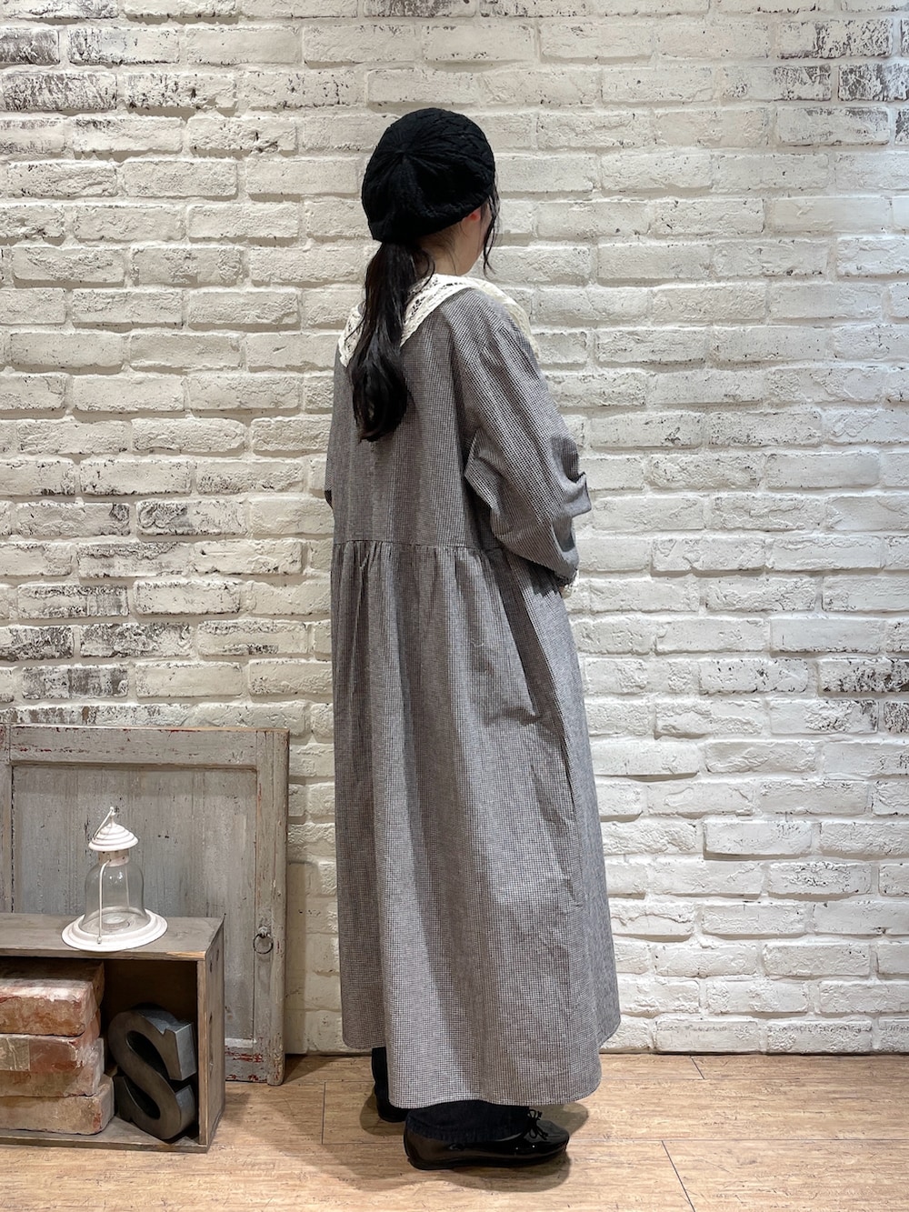 ブラック系のハンドバッグ、ブルー系のデニムパンツ、ブラック系のパンプスを着用したレディースの冬コーディネートの2枚目の写真