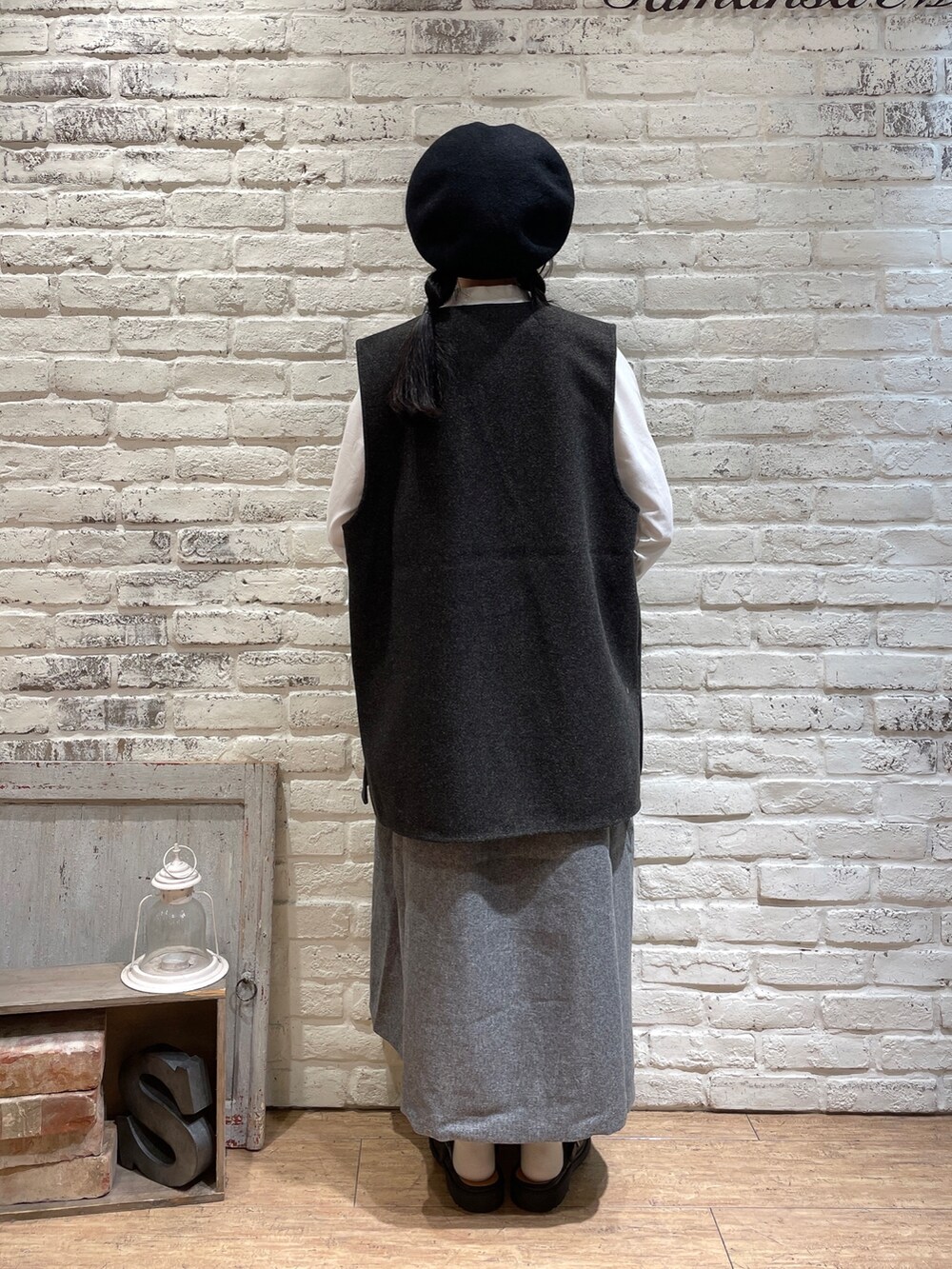 ブラウン系のベスト、グレー系のワンピース、ブラック系のハンドバッグを着用したレディースの秋コーディネートの5枚目の写真