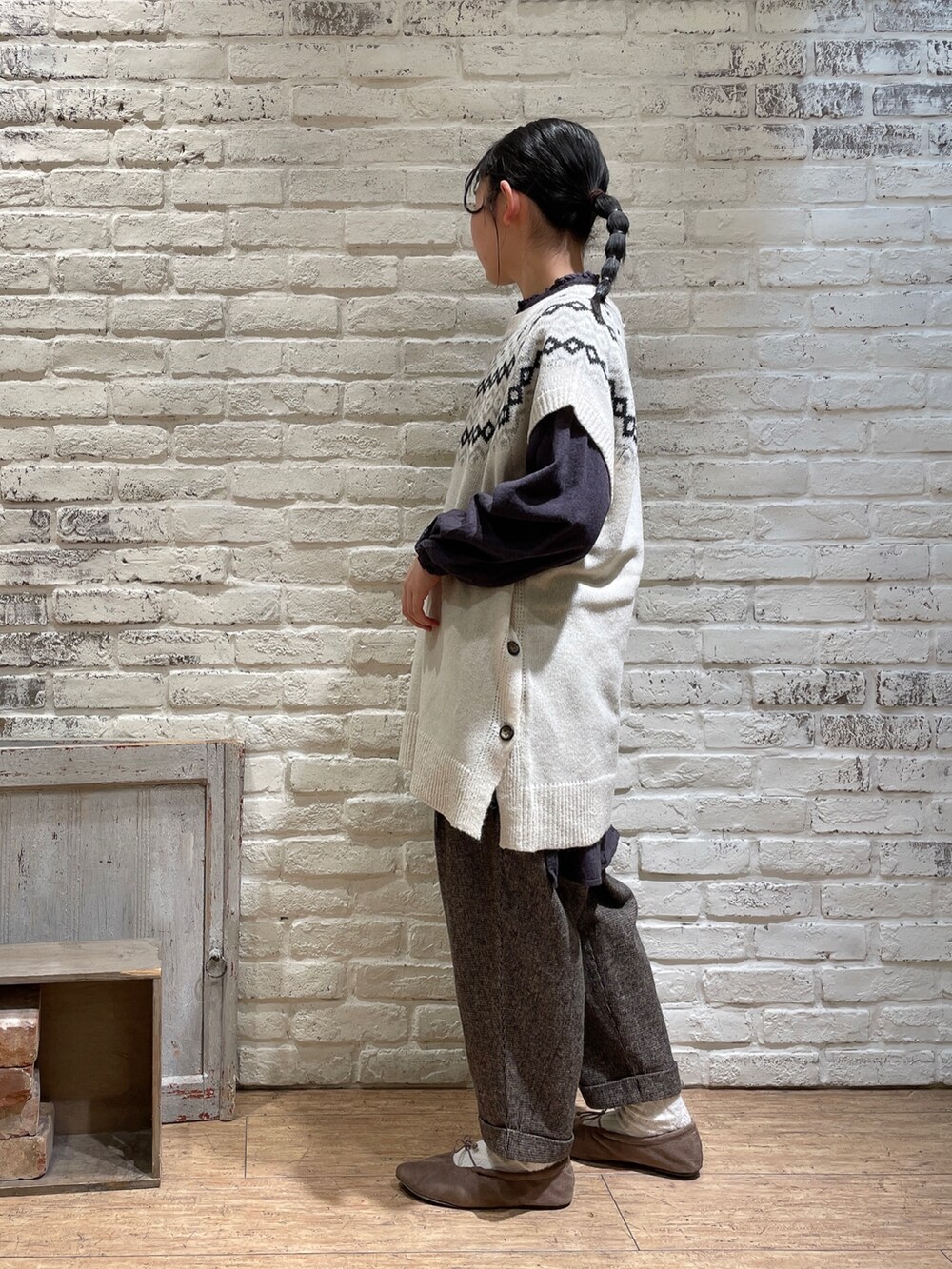ホワイト系のベスト、ブラウン系のその他パンツ、ブラウン系のバレエシューズを着用したレディースの冬コーディネートの2枚目の写真