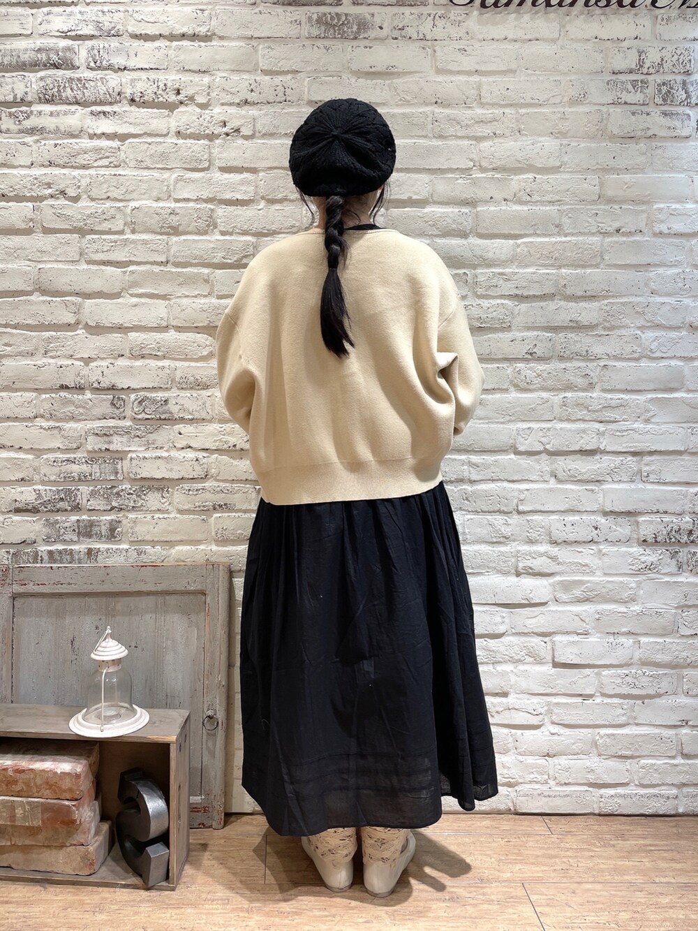 ブラック系のワンピース、ホワイト系のカーディガン/ボレロ、ホワイト系のバッグを着用したレディースの冬コーディネートの3枚目の写真