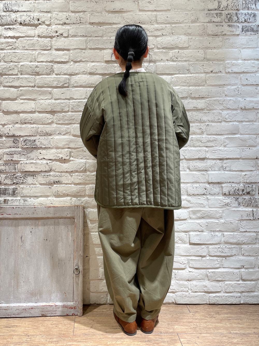 ブルー系のシャツ/ブラウス、ホワイト系のTシャツ/カットソー、グリーン系のノーカラージャケットを着用したレディースの冬コーディネートの3枚目の写真