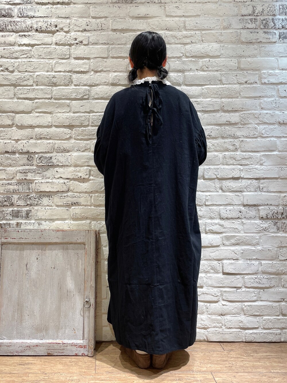 ブラック系のワンピース、ブラウン系のバレエシューズ、ホワイト系のシャツ/ブラウスを着用したレディースの冬コーディネートの3枚目の写真