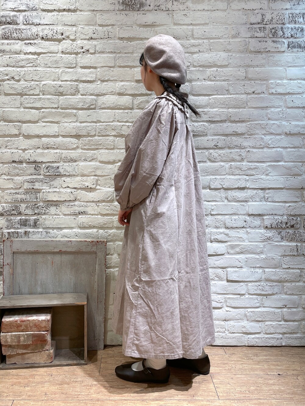 ブラウン系のハンドバッグ、ベージュ系のワンピース、ブラウン系のパンプスを着用したレディースの秋コーディネートの2枚目の写真