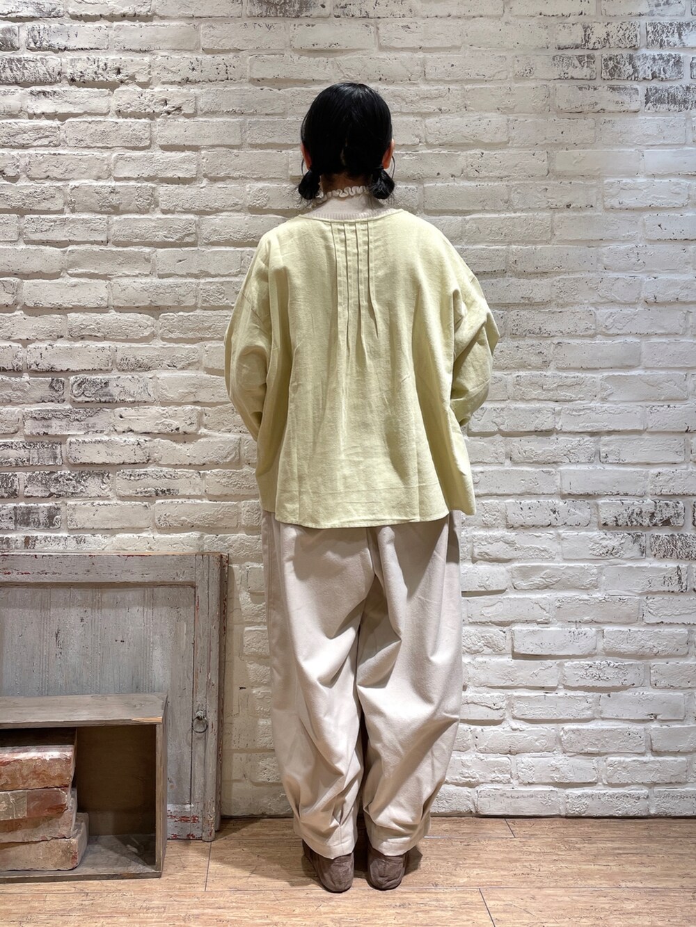 ホワイト系のニット/セーター、イエロー系のシャツ/ブラウス、ブラウン系のハンドバッグを着用したレディースの冬コーディネートの3枚目の写真