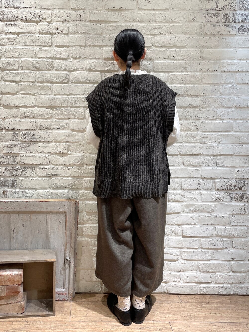 ホワイト系のシャツ/ブラウス、グレー系のベスト、ブラック系のパンツを着用したレディースの冬コーディネートの3枚目の写真