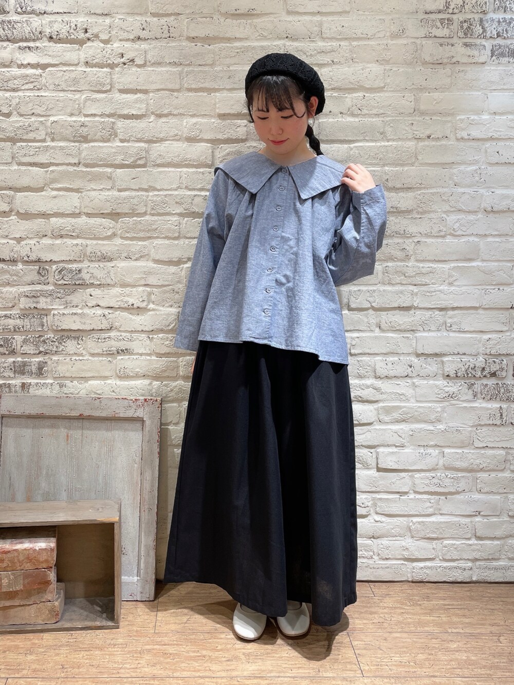ブルー系のシャツ/ブラウス、ブルー系のベスト、ブラック系のハンドバッグを着用したレディースの春コーディネートの2枚目の写真