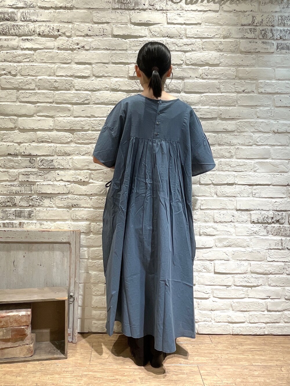 ベージュ系のトートバッグ、グリーン系のワンピース、ホワイト系のTシャツ/カットソーを着用したレディースの夏コーディネートの4枚目の写真