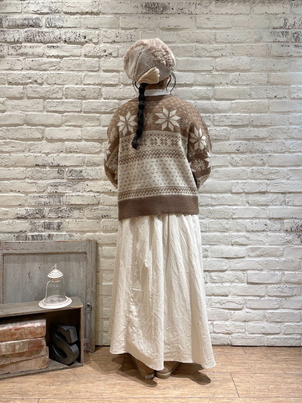 ブラウン系のカーディガン/ボレロ、ホワイト系のTシャツ/カットソー、ベージュ系のスカートを着用したレディースの冬コーディネートの3枚目の写真