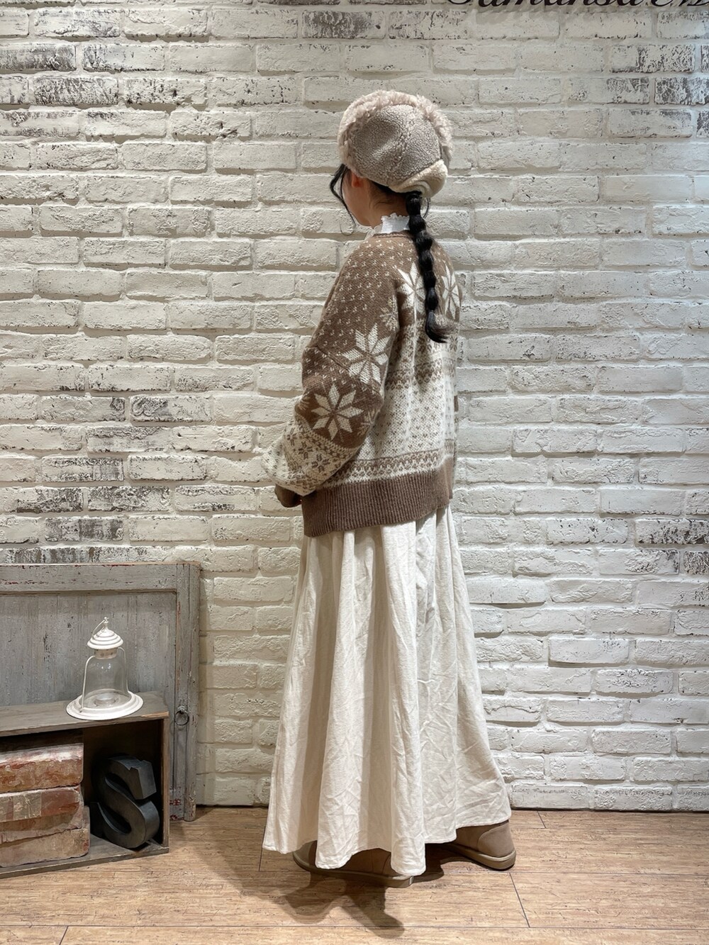 ブラウン系のカーディガン/ボレロ、ホワイト系のTシャツ/カットソー、ベージュ系のスカートを着用したレディースの冬コーディネートの2枚目の写真