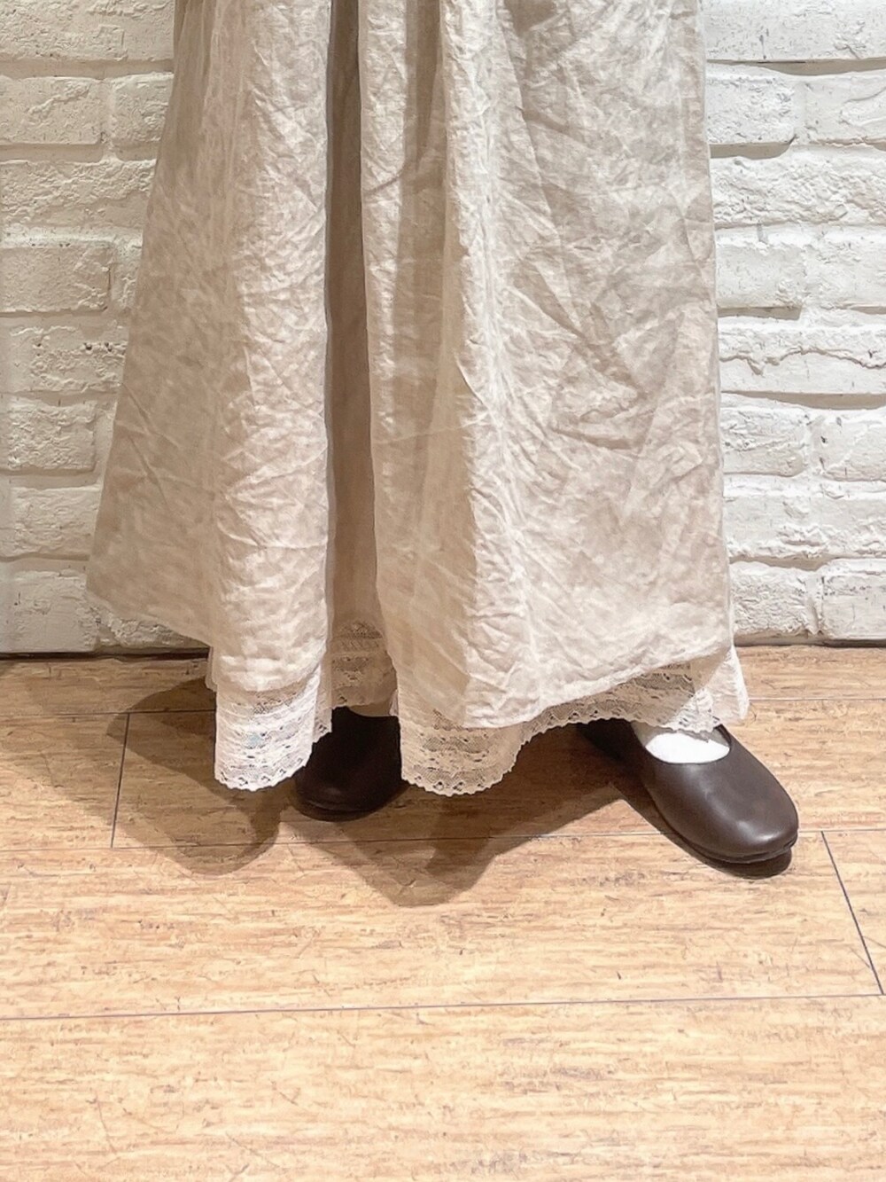 ホワイト系のベスト、ブラウン系のその他パンツ、ブラウン系のパンプスを着用したレディースの秋コーディネートの2枚目の写真