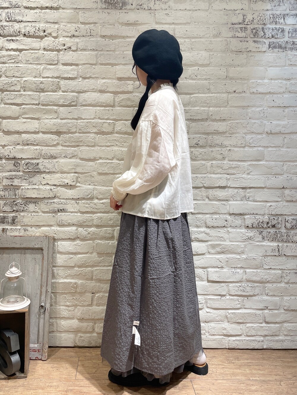 ホワイト系のシャツ/ブラウス、ブラック系のハンドバッグ、ブルー系のスカートを着用したレディースの秋コーディネートの2枚目の写真