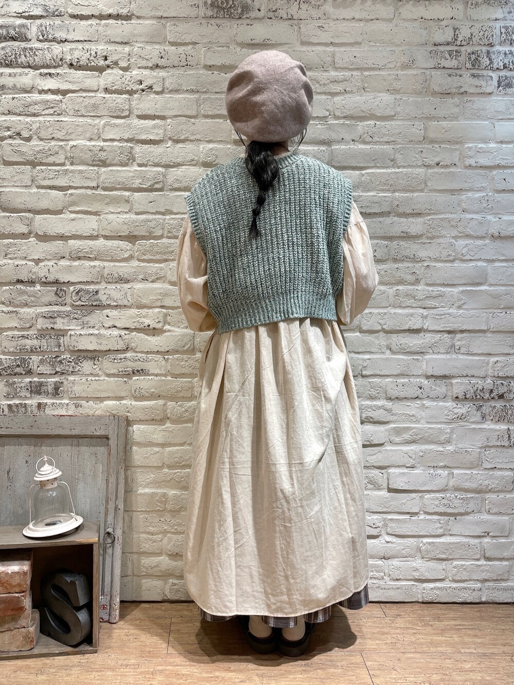 グリーン系のベスト、ブラック系のハンドバッグ、ブラウン系のワンピースを着用したレディースの秋コーディネートの3枚目の写真