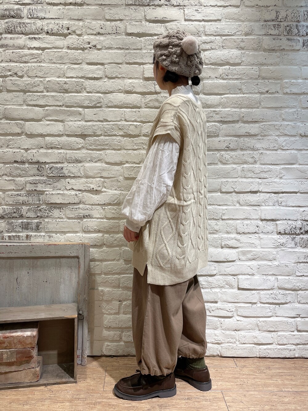 ブルー系のシャツ/ブラウス、ホワイト系のベスト、ブラウン系のトートバッグを着用したレディースの秋コーディネートの2枚目の写真