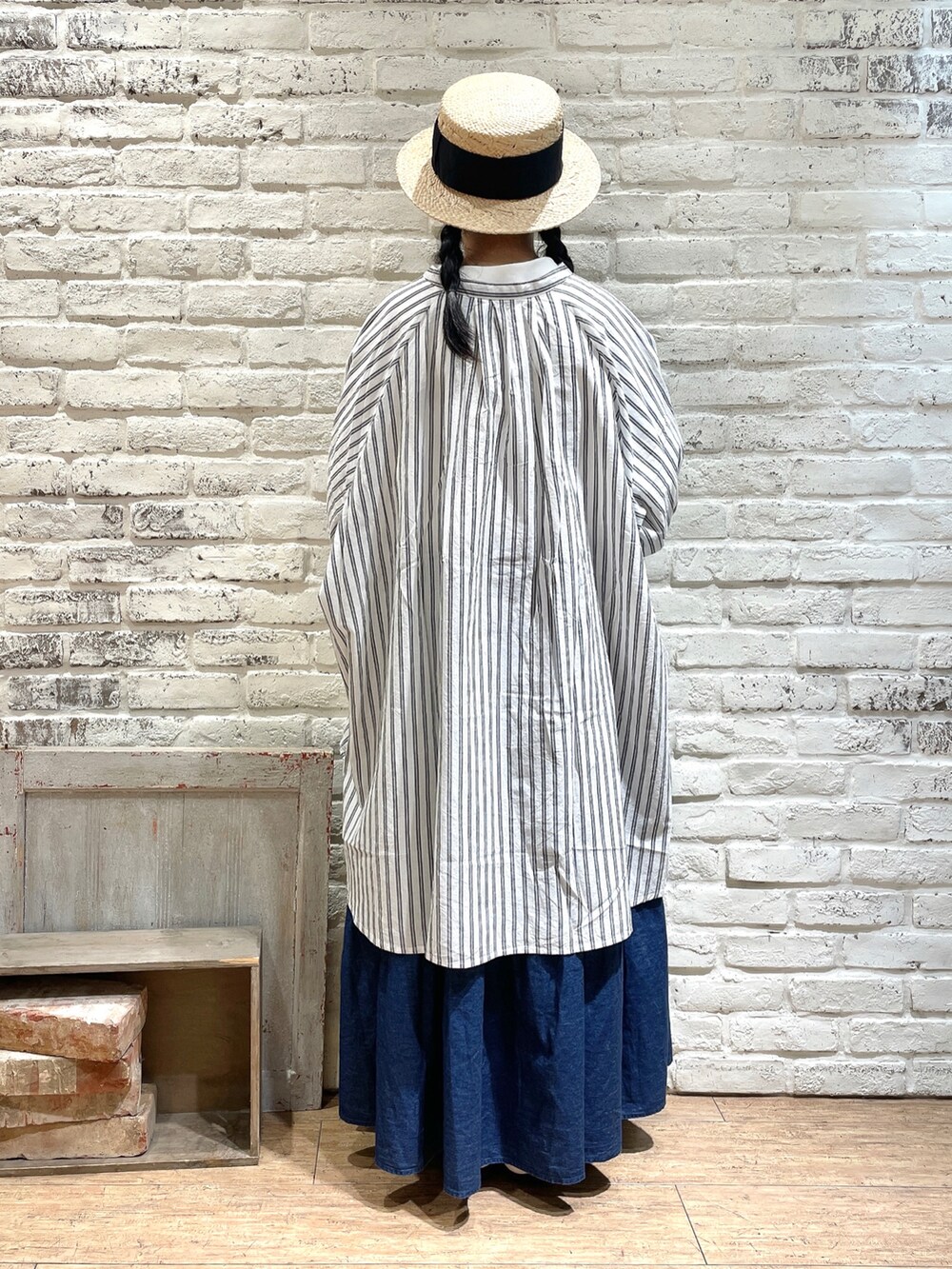 ブラウン系のチュニック、ホワイト系のTシャツ/カットソー、ブルー系のスカートを着用したレディースの夏コーディネートの3枚目の写真