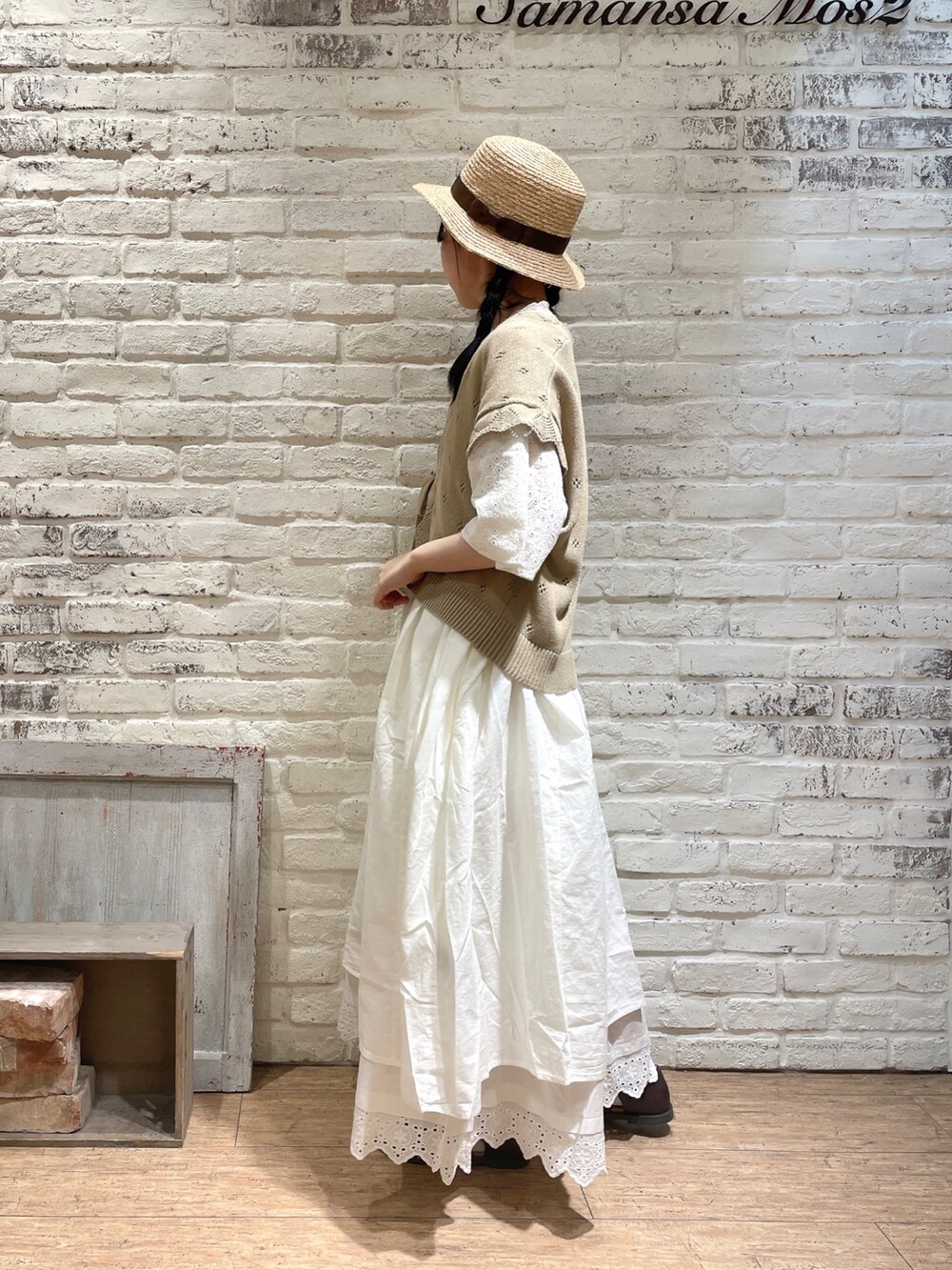 グリーン系のベスト、ホワイト系のワンピース、ホワイト系のスカートを着用したレディースの春コーディネートの2枚目の写真