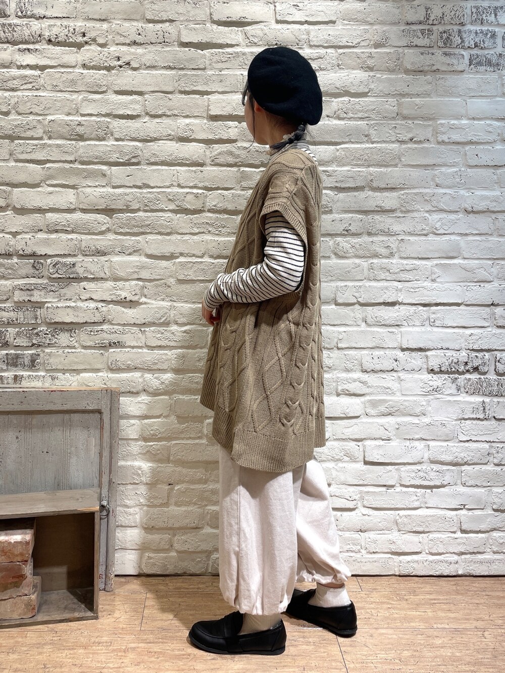 ホワイト系のニット/セーター、ベージュ系のベスト、グレー系のハンドバッグを着用したレディースの秋コーディネートの2枚目の写真