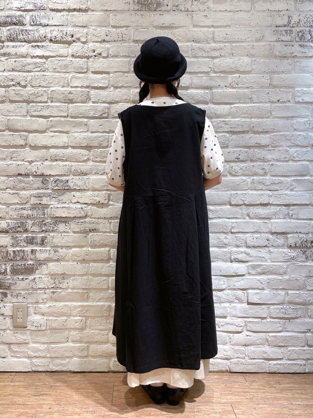 ホワイト系のTシャツ/カットソー、ブラック系のワンピース、ベージュ系のハンドバッグを着用したレディースの秋コーディネートの3枚目の写真