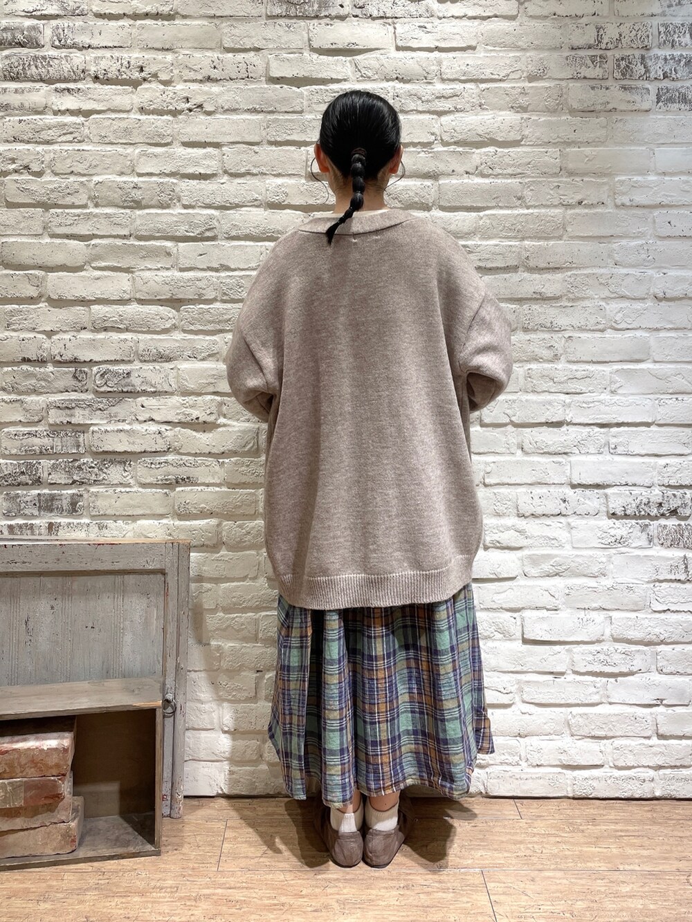 ホワイト系のTシャツ/カットソー、ベージュ系のカーディガン/ボレロ、グリーン系のスカートを着用したレディースの秋コーディネートの3枚目の写真