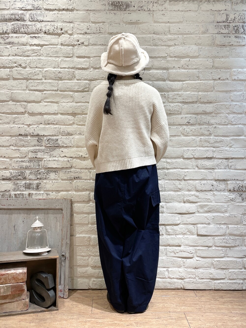 ホワイト系のニット/セーター、ブラック系のハンドバッグ、グリーン系のワンピースを着用したレディースの秋コーディネートの2枚目の写真